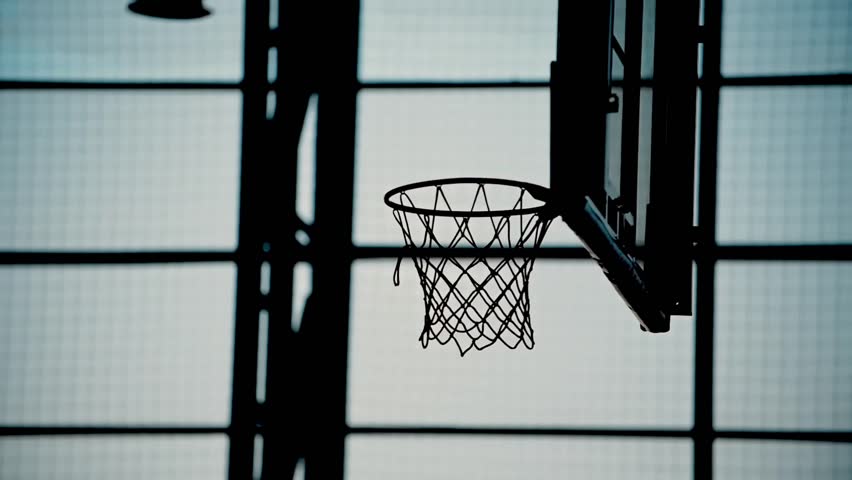 The silhouette of a basketball hoop into which the ball hits.Playing basketball indoors | Shutterstock HD Video #1100237061