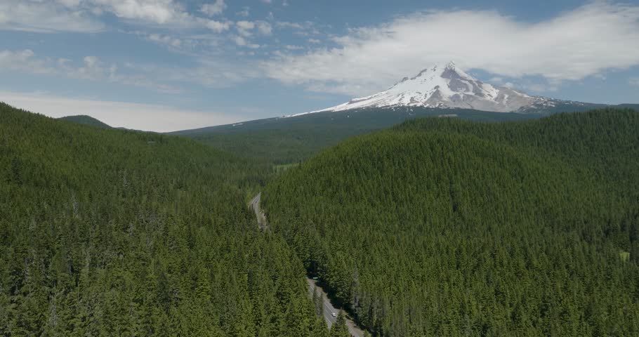Aerial view of Mt Hood forest with cars driving toward mountain