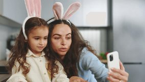 A Happy Family Is Preparing for the Easter Holiday Using Smartphone to Video Calling. Mom and Daughter Paint Eggs, Communicate With Friends Through Video. Happy Easter