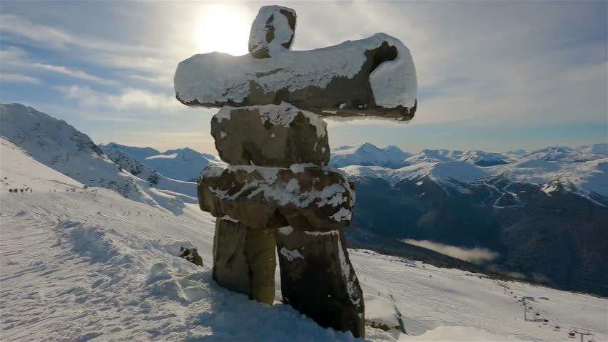 Whistler, British Columbia, Canada. Beautiful View of Statue on top of Blackcomb Mountain with the Canadian Snow Covered Landscape in background during a cloudy and vibrant winter day. Slow Motion Royalty-Free Stock Footage #1100240437