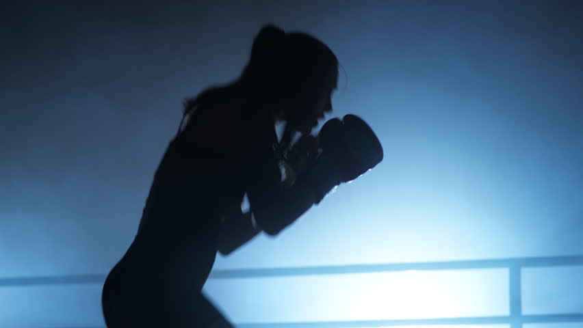 Portrait of slim woman training to build strong muscles and toned body. Close-up shot of active woman in boxing gloves warming up before a sparring in the ring. High quality 4k footage