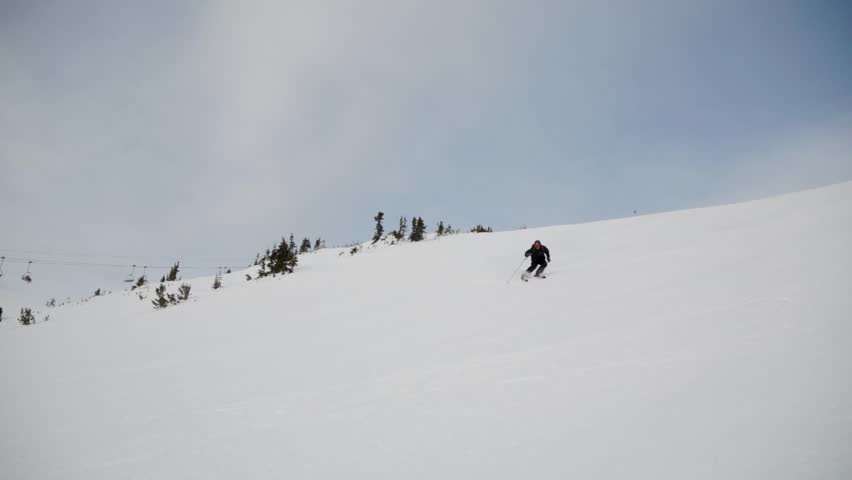 Fast downhill skiers with sunstar, ski mountain, sunny day, winter, ski hill, Whistler BC. HD 24fps