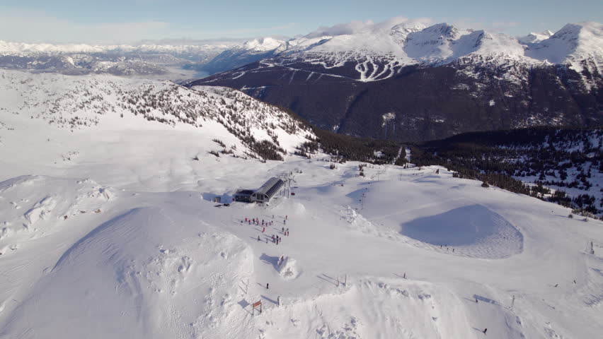 Aerial drone footage of Whistler mountain, BC, ski hill on a sunny day, chairlift, Whistler peak, ski run, skier, winter sport. 5.4K 24FPS PRORES 422