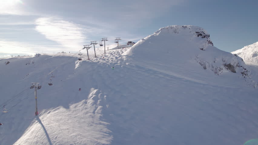 Aerial drone footage of Whistler mountain, BC, ski hill on a sunny day, chairlift, Whistler peak, ski run, skier, winter sport. 5.4K 24FPS PRORES 422