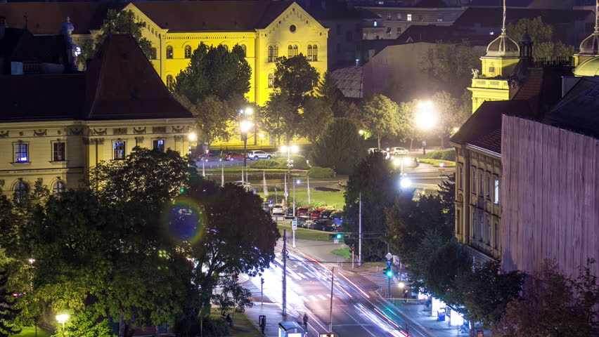 Zagreb city center night timelapse shoot from top of skyscraper with aerial view to the intersection in front of national theater and museum in Croatia. Traffic on the road
