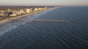 Aerial view of the Jacksonville Beach Fishing Pier during sunrise.