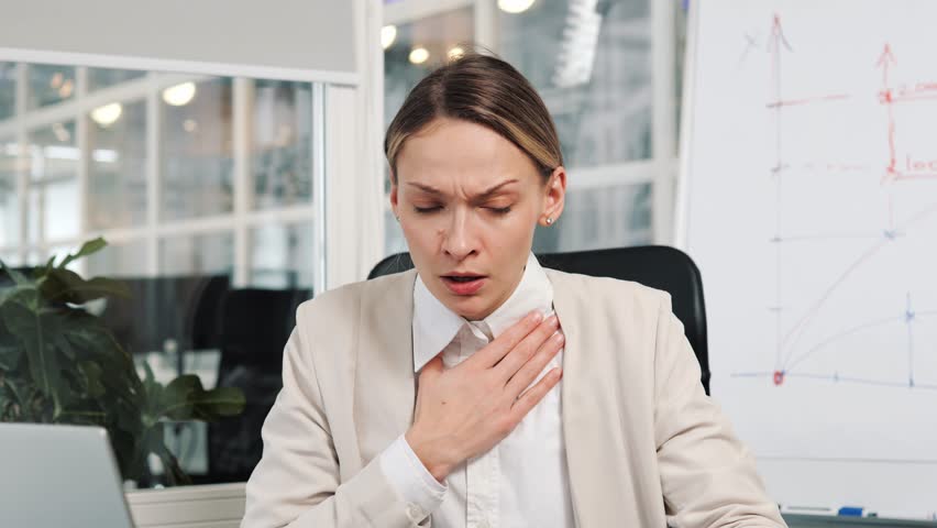 Heart attack, thoracic osteochondrosis, asthma, osteochondrosis concepts. Breathing problems, chest pain, panic attack at work. Business woman has difficulty breathing, female hand touches chest.  Royalty-Free Stock Footage #1100249435