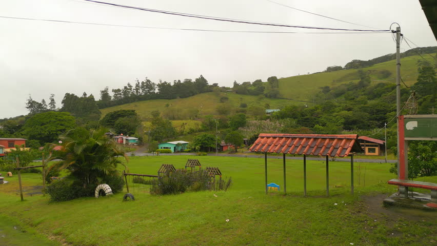 Forwards fly above children playground at football field. Vibrant green colour of lawn. La Fortuna, Costa Rica