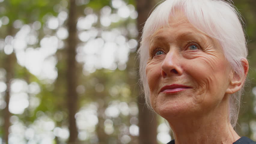 Portrait of smiling active senior woman with backpack on hike through woodland countryside enjoying peace and beauty of nature- shot in slow motion | Shutterstock HD Video #1100255749