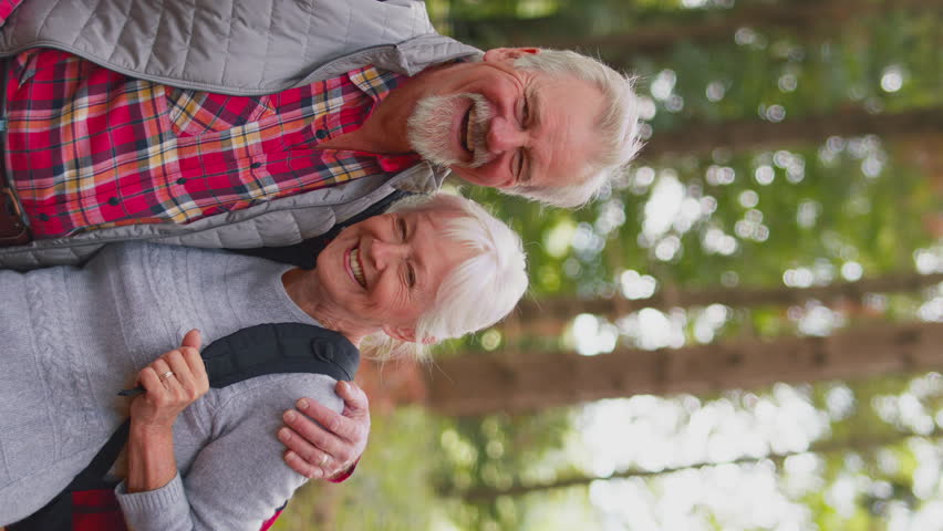 Vertical video portrait of Vertical video of smiling active senior couple on hike through woodland countryside together  - shot in slow motion | Shutterstock HD Video #1100255831