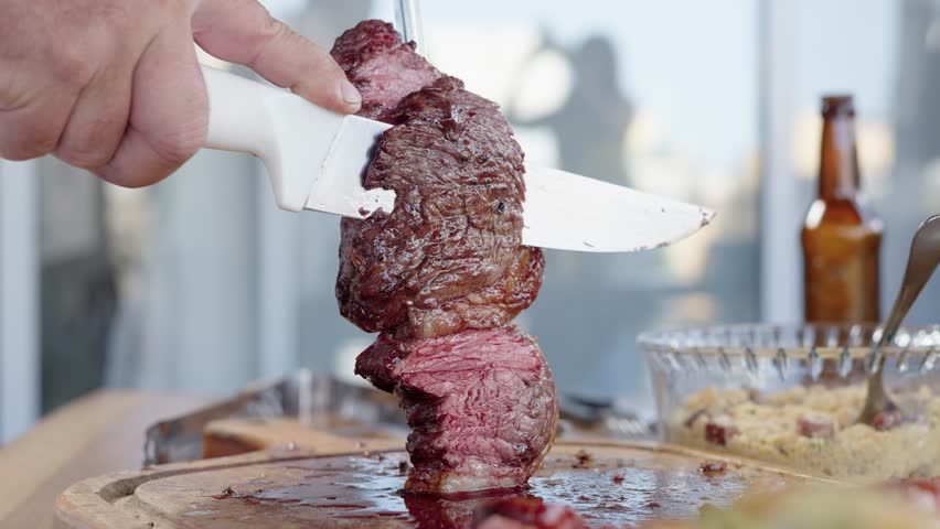 Close up of juicy Picanha on brazilian family Traditional Churrasco Brazilian Barbecue. Being Cut
 Royalty-Free Stock Footage #1100259449