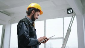 Happy constructor worker man holding digital tablet to analysing some work at construction site he wearing special uniform and safety yellow helmet - Powered by Shutterstock - Get 15% off with code: PIKWIZARD15