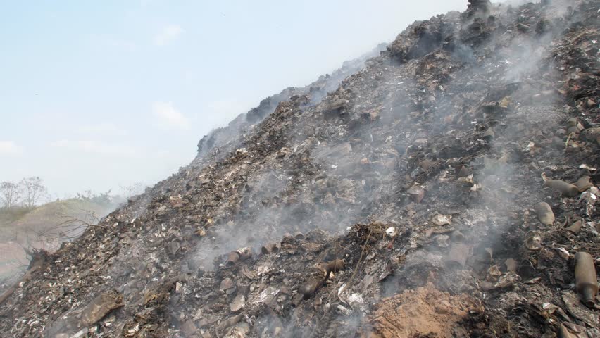 Garbage and fire burn in landfill.
Occurs smoke, toxic cause of air pollution, environmental damage and global warming.
 | Shutterstock HD Video #1100260777