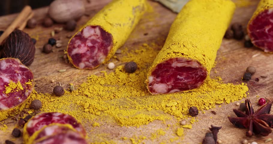 Slicing pork sausage marinated in a large amount of turmeric , dried meat with spices close - up