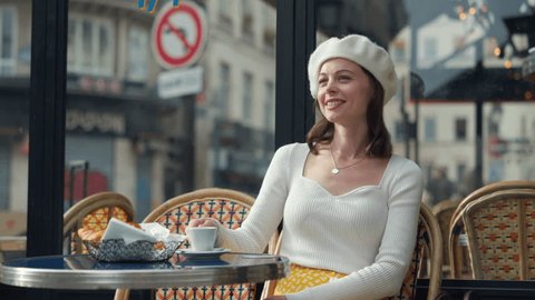 Attractive girl drinking coffee at a table in an outdoor cafe Arkistovideo