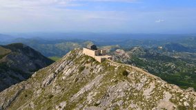 This stock video showcases the breathtaking aerial footage of the Njegos Mausoleum located at the top of the Jezerski peak in Montenegro. The mausoleum is a stunning architectural masterpiece
