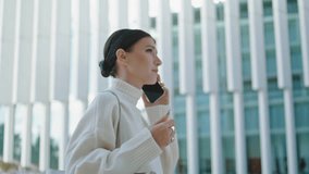 Elegant successful businesswoman talking smartphone going to office close up. Stylish young lady calling by modern telephone walking alone outdoors. Relaxed pretty woman have phone conversation. - Powered by Shutterstock - Get 15% off with code: PIKWIZARD15