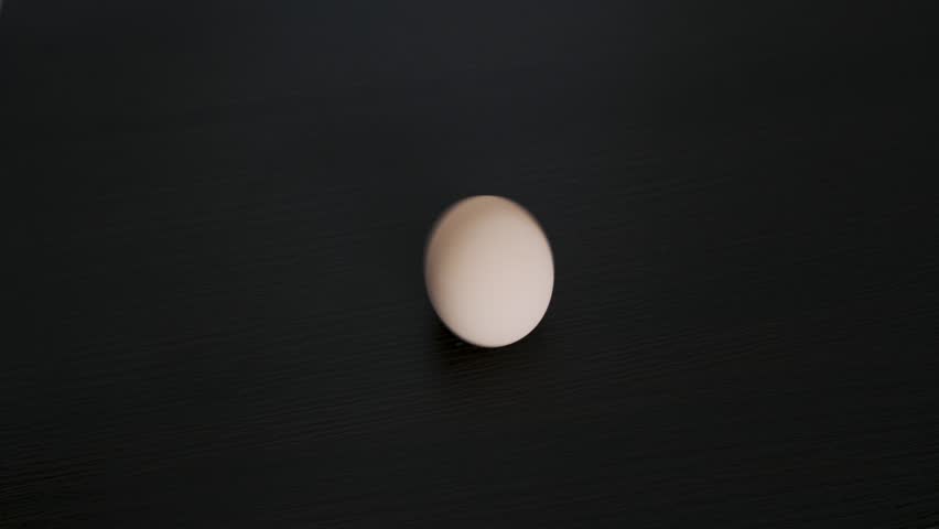 A chicken egg rotates around its axis. Close-up Royalty-Free Stock Footage #1100267689