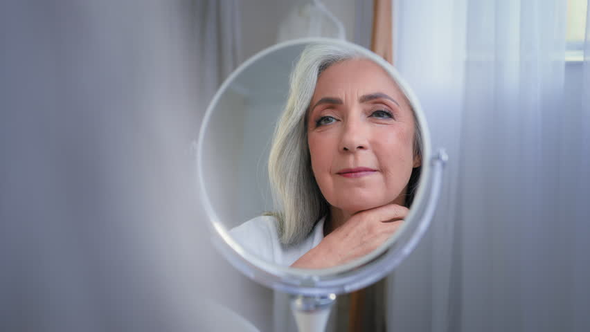 Mirror reflection female wrinkled face 50s middle-aged Caucasian woman senior lady looking self lover skin care grandmother thinking pampering mirrored soft facial beauty cosmetology rejuvenation Royalty-Free Stock Footage #1100270845