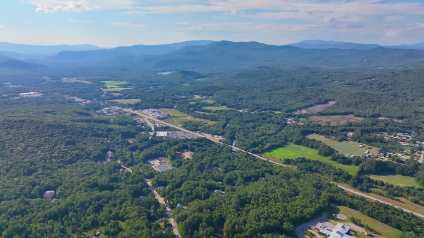 Plymouth State University and Pemigewasset River aerial view with White Mountain National Forest at the background in summer in historic town center of Plymouth, New Hampshire NH, USA. 