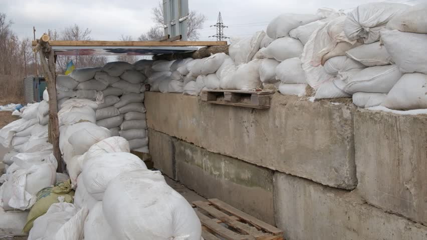 Checkpoint in Ukraine. Barricade of concrete slabs and bags of sand.