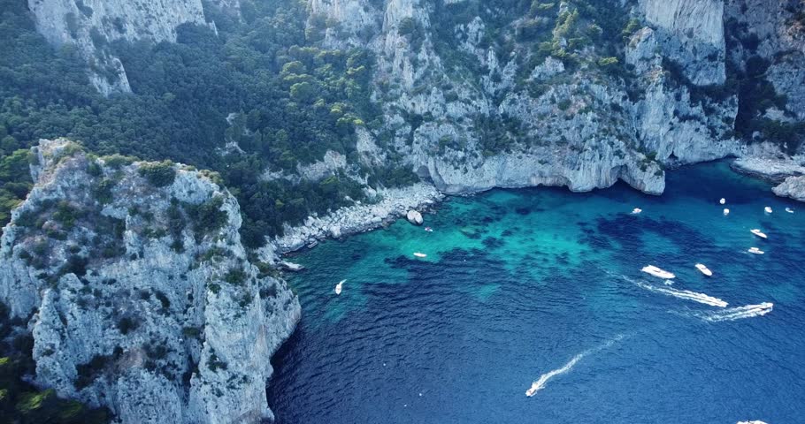 Aerial view of the three Faraglioni rocks off the Capri island. Aerial drone view of the Tyrrhenian sea coast of Capri, Italy. Coastal of azure Tyrrhenian Sea, Capri, island of Gulf of Naples, Italy | Shutterstock HD Video #1100279967