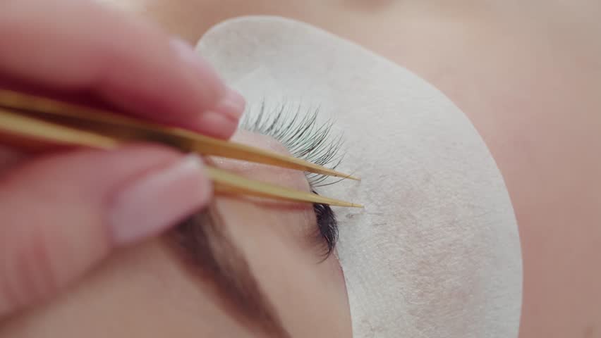 The master performs the procedure of eyelash extensions Royalty-Free Stock Footage #1100280499
