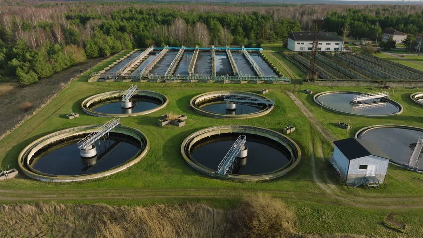 Aerial establishing view of water basins at sewage treatment plant, ponds for recycling dirty wastewater, recycle system technology, waste management theme, drone dolly shot moving right | Shutterstock HD Video #1100284835