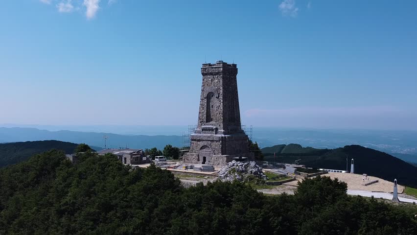 Shipka Monument. A beautiful mountain in Bulgaria. A monument of architecture. The tower of the castle in the mountains. A fortress in the mountains. Landscape. Blue sky and lots of plants. 