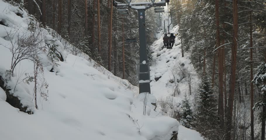 Tourists climb up the mountain using a suspended cable lift. The town of Belokurikha, Siberia. Hand held.