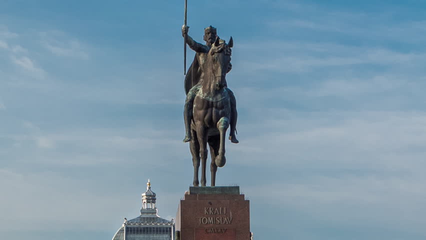 Monument of the Croatian King Tomislav timelapse hyperlapse and art pavilion in colorful park, in Zagreb, capital of Croatia. Blue cloudy sky before sunset. Close up view