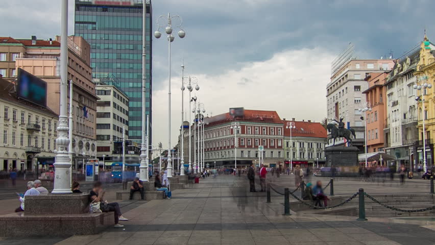 Central city square (Trg bana Jelacica) timelapse hyperlapse and Ban Jelacic monument in Zagreb, Croatia. The oldest standing buildings and blue trams passing by