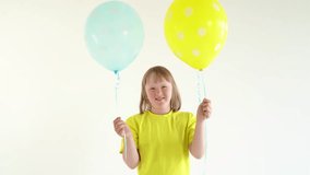 Young girl with down syndrome holding two blue and yellow balloons isolated on white background. World down syndrome day background. Down syndrome awareness concept. - Powered by Shutterstock - Get 15% off with code: PIKWIZARD15