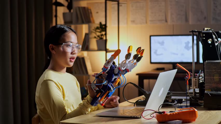 Satisfied Teen Asian Girl Looking And Checking A Cyborg Hand While Working On A Laptop At Home
 Royalty-Free Stock Footage #1100304071