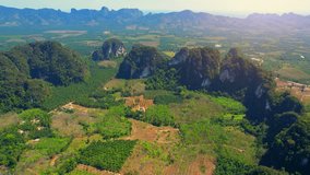 Amazing scenery over Limestone mountains and agricultural areas. Krabi, Southern Thailand. tropical scenery. Travel destination. nature and travel concept. video background. aerial view 4K UHD. Drone
