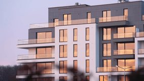 4k time lapse video with the sunset orange sky reflection in the windows of a new modern residential apartment building