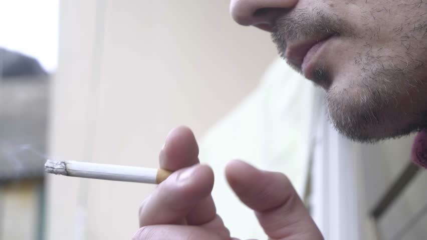 A young guy smokes a cigarette close-up. Harm of smoking | Shutterstock HD Video #1100310423