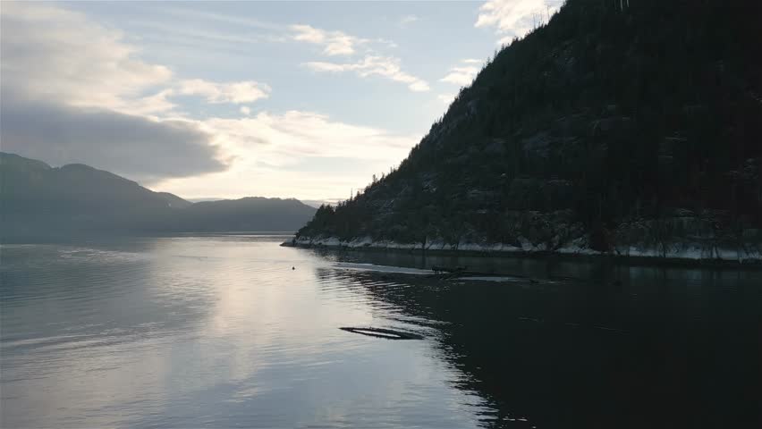 Ocean Inlet with Rocky Mountains in Canadian Landscape. Aerial Nature Background. Howe Sound, Squamish, BC, Canada. Sunset. Cinematic Royalty-Free Stock Footage #1100311011