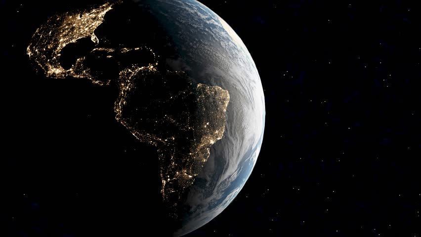 Satellite view at night over South America showing glowing lights of populated cities, darkness over Amazon rainforest