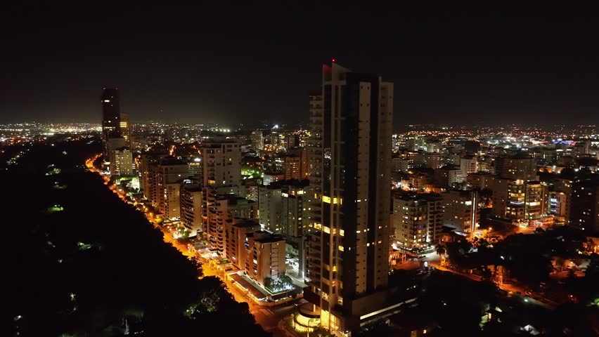 Residential Skyscraper And Modern Buildings Lit At Night Along Avenida Anacaona In Downtown Santo Domingo, Dominican Republic. aerial