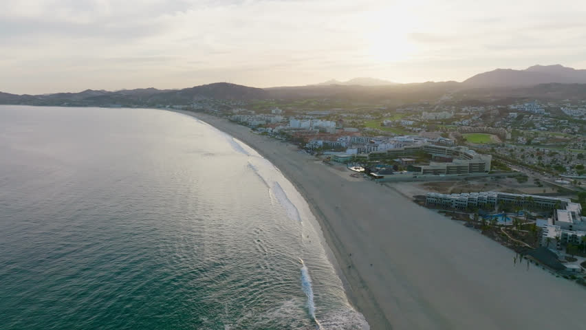 Aerial View of Coastal Hotels Resort Along Empty Sandy Beach Shore at Sunset in Baja Mexico, Coastline Seascape and Tourism