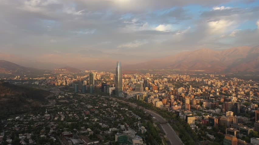 Santiago City at Sunset and Andes Mountains. Aerial View. Chile. Drone Flies Forward