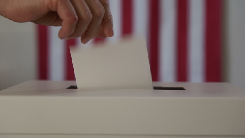 A person casts her ballot during voting for elections at a polling station. Close up shot footage
