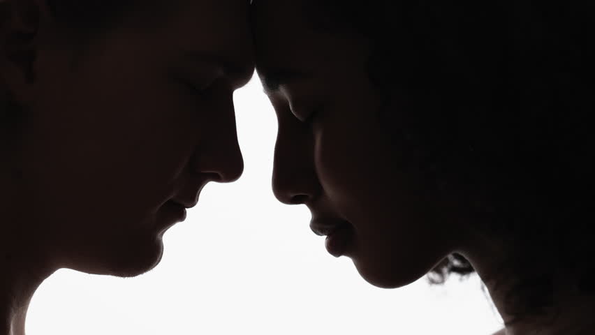 Couple unity. Romantic feelings. Silhouette portrait. Smiling profile shadow man and woman staying close with forehead each other on white background.