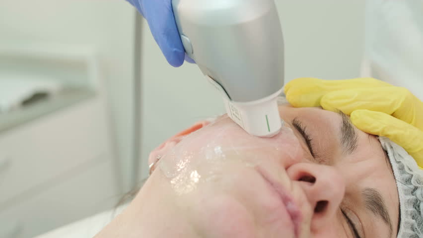 Professional face skin rejuvenation, lifting procedure. Cosmetologist uses modern ultrasound device. Hardware cosmetology Royalty-Free Stock Footage #1100317141
