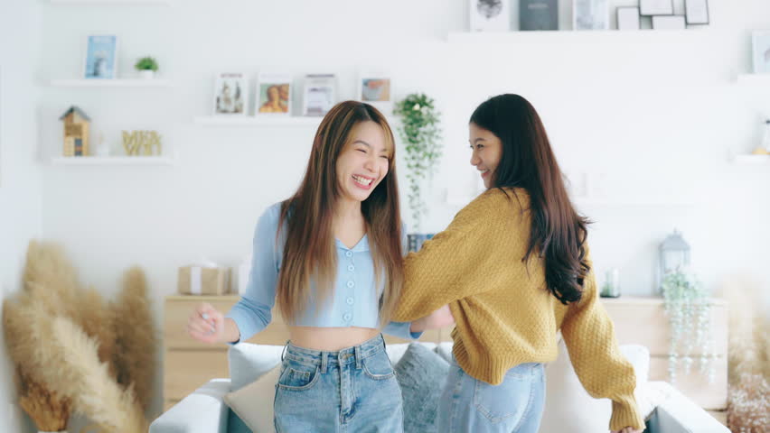 Two asian young woman recording trend dance video on smartphone in living room. Overjoyed teen girl dancing to favorite energetic music, having fun with joyful | Shutterstock HD Video #1100320877