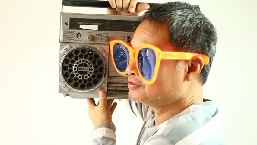 Middle age man is listening radio cassette , in studio Chiangmai Thailand.