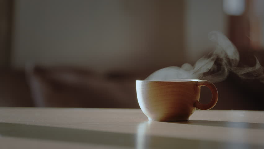 Wooden coffee cup or tea cup with natural steam smoke. Close-up of Smoke rises from cup, cup of coffee for breakfast in the morning time with warm light. Hot Coffee Drink Concept. Royalty-Free Stock Footage #1100321121