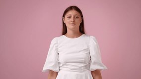 4k video of one girl with crossed hands on pink background.