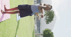 Vertical video of african american schoolchildren practicing yoga in outdoor class, copy space. Education, childhood, health, inclusivity, school and learning concept.